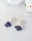 Top-angle view of raw sapphire stud earrings showing the natural blue stones and minimalist sterling silver design