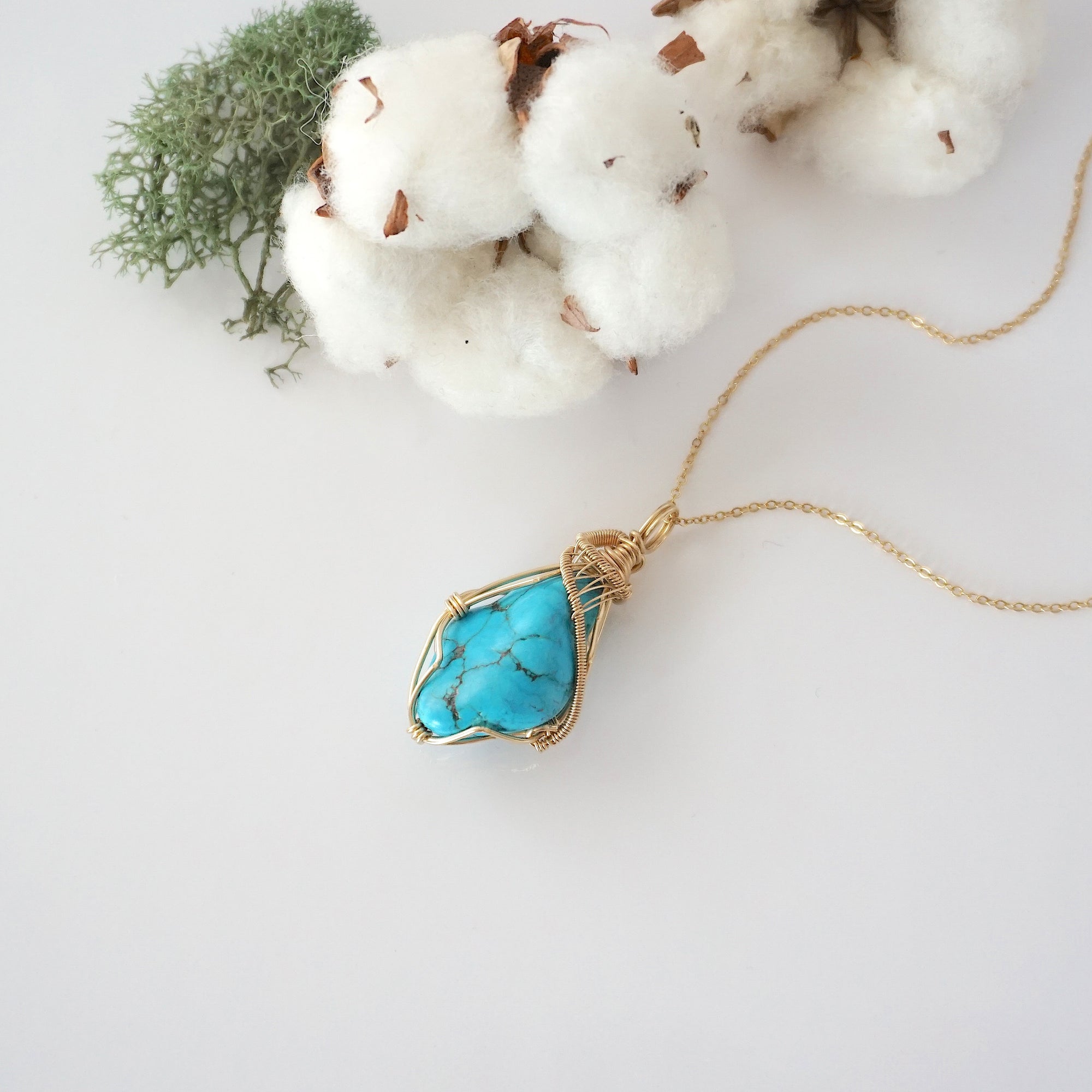 Raw turquoise necklace in 14k gold filled laying flat. Handcrafted December birthstone jewelry for women by Designs by Nature Gems.