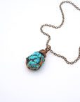 Raw turquoise necklace with antique bronze copper wire wrapping on chain, handmade crystal healing pendant flat lay