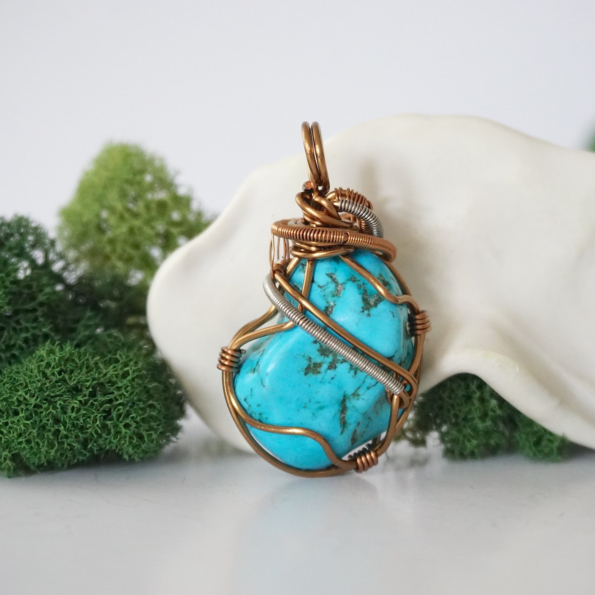 Back view of detailed wire wrapped raw turquoise pendant showing antique bronze copper craftsmanship and technique