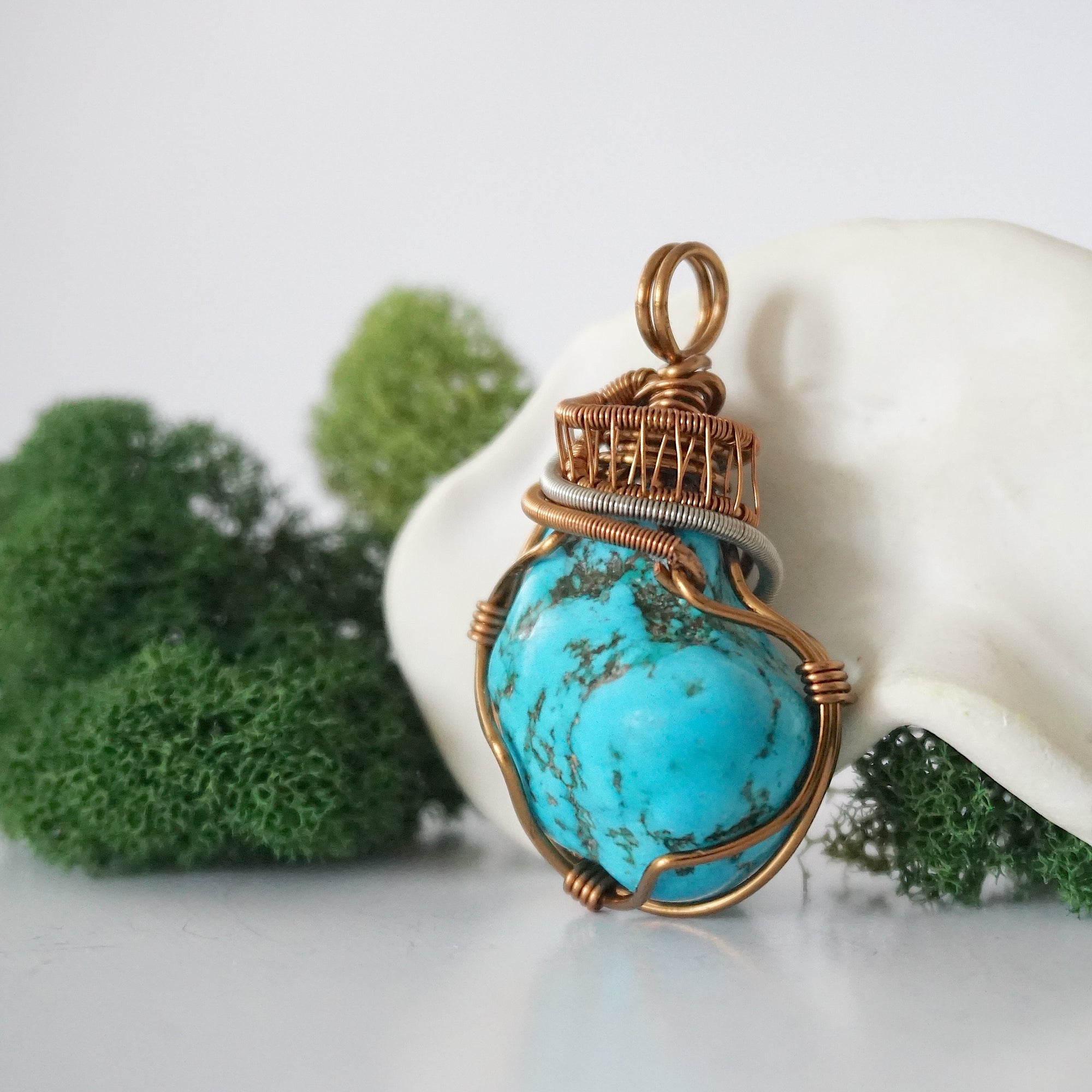 Side angle of raw turquoise pendant showing intricate wire wrap detail with tin plated copper accents and texture