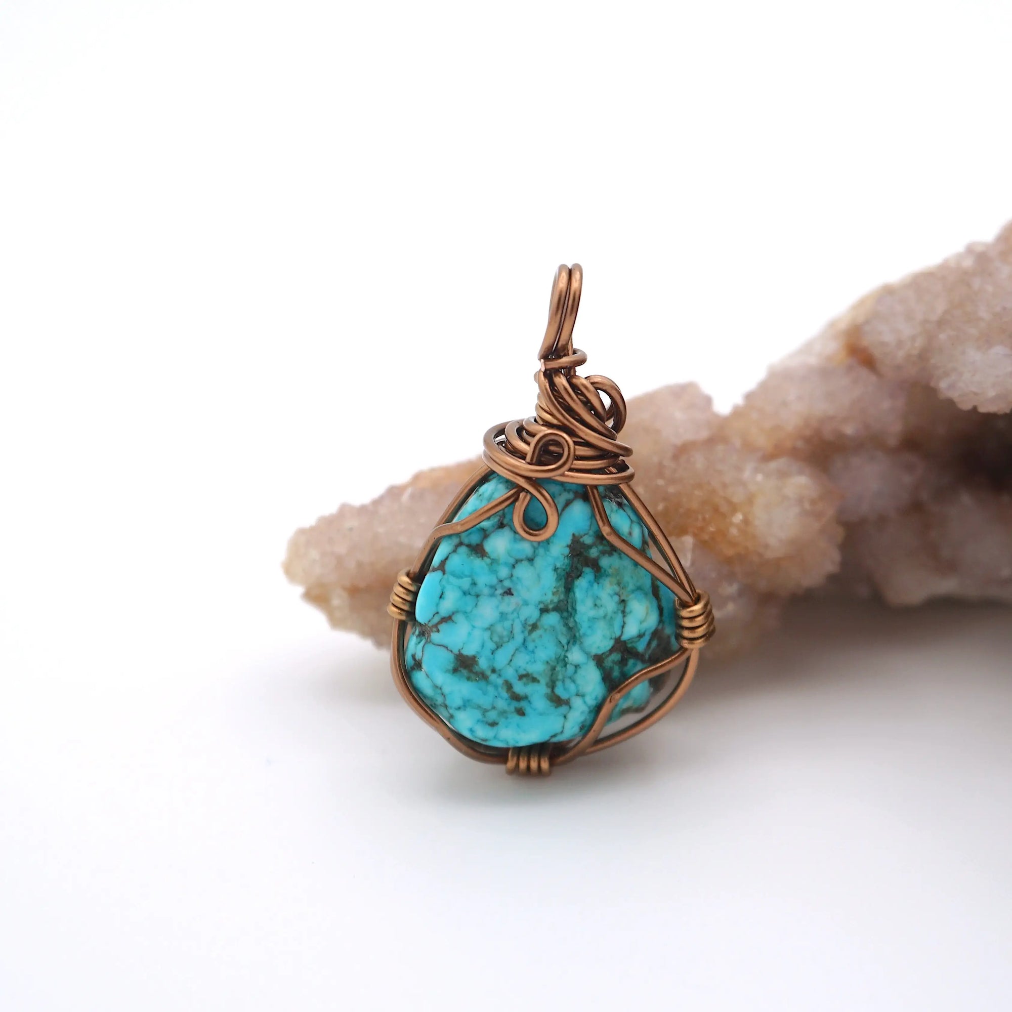 Back view of wire wrapped raw turquoise pendant showing antique bronze copper craftsmanship and artisan technique