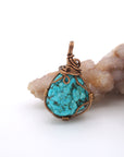 Back view of wire wrapped raw turquoise pendant showing antique bronze copper craftsmanship and artisan technique