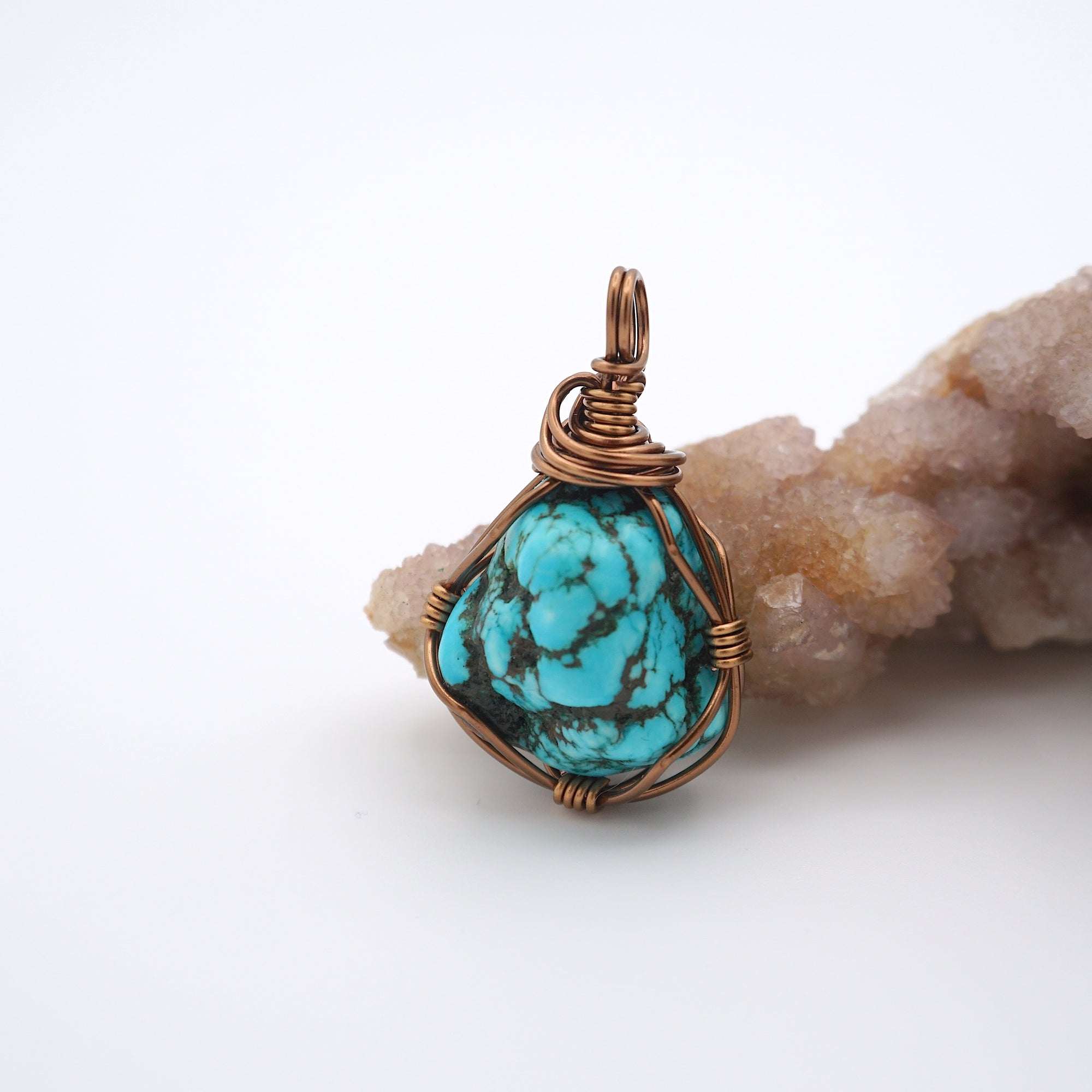 Front view of raw turquoise crystal pendant with simple antique bronze wire wrapping, handmade healing stone jewelry