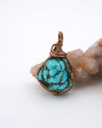 Front view of raw turquoise crystal pendant with simple antique bronze wire wrapping, handmade healing stone jewelry