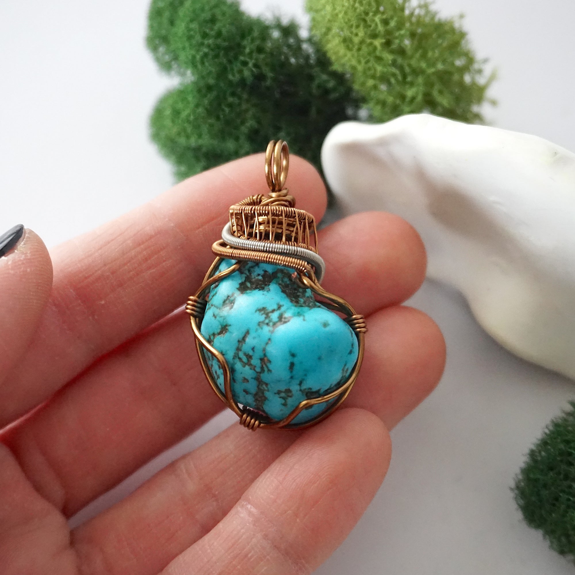 Raw turquoise pendant in hand showing size, detailed wire wrapped crystal necklace with copper accents scale reference