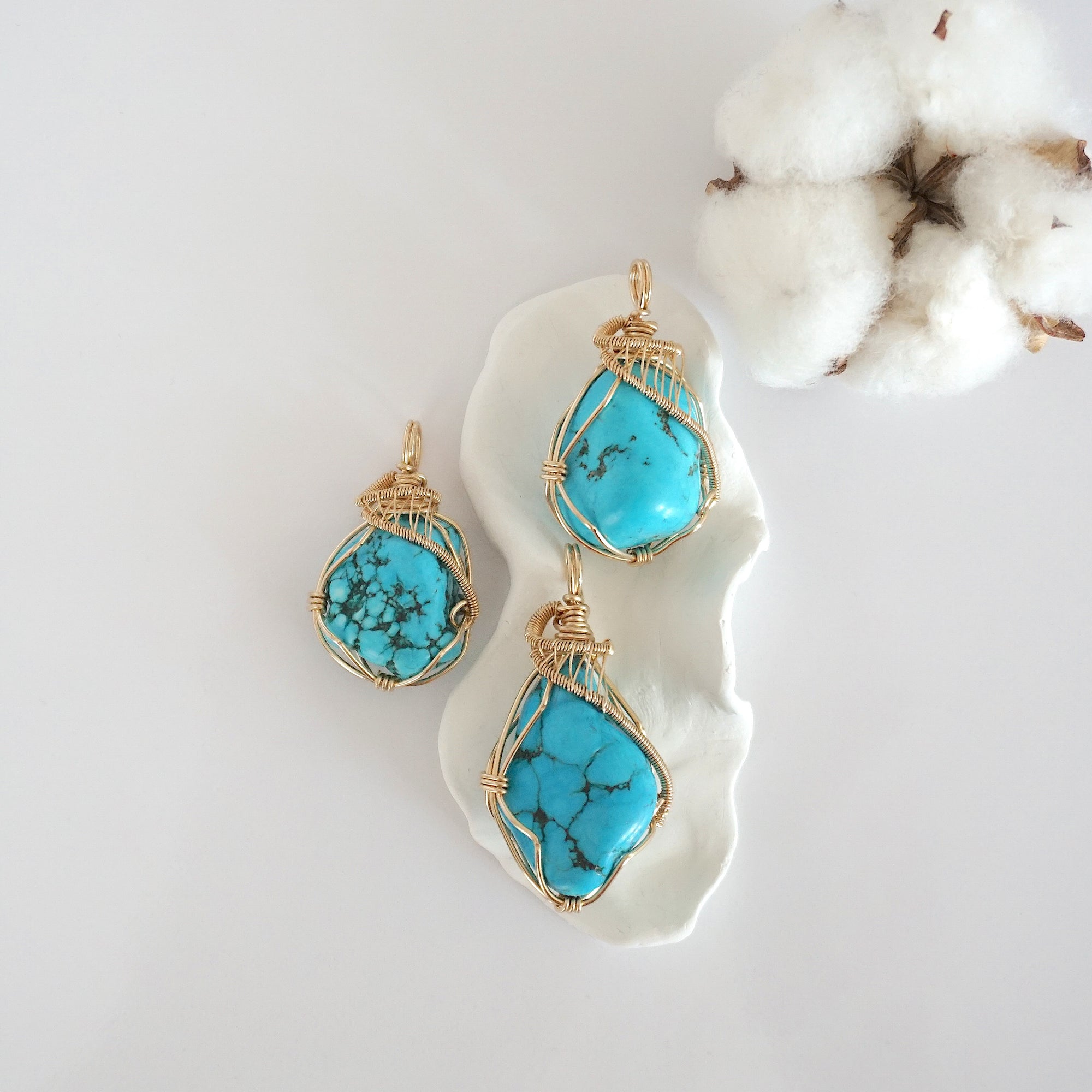 Three raw turquoise pendants in 14k gold filled, showing natural variation in size, shape, and color. Handcrafted December birthstone jewelry by Designs by Nature Gems.