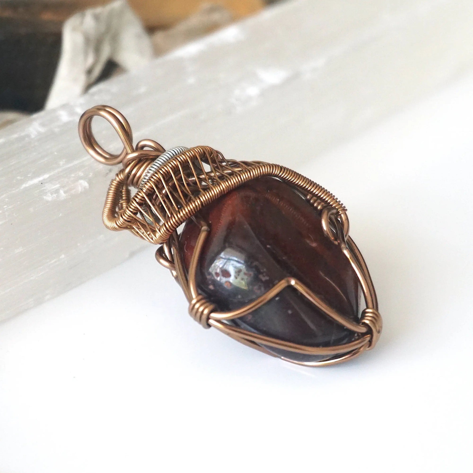 Right side angle detail of natural red tiger's eye pendant, wire wrapped by Designs by Nature Gems.
