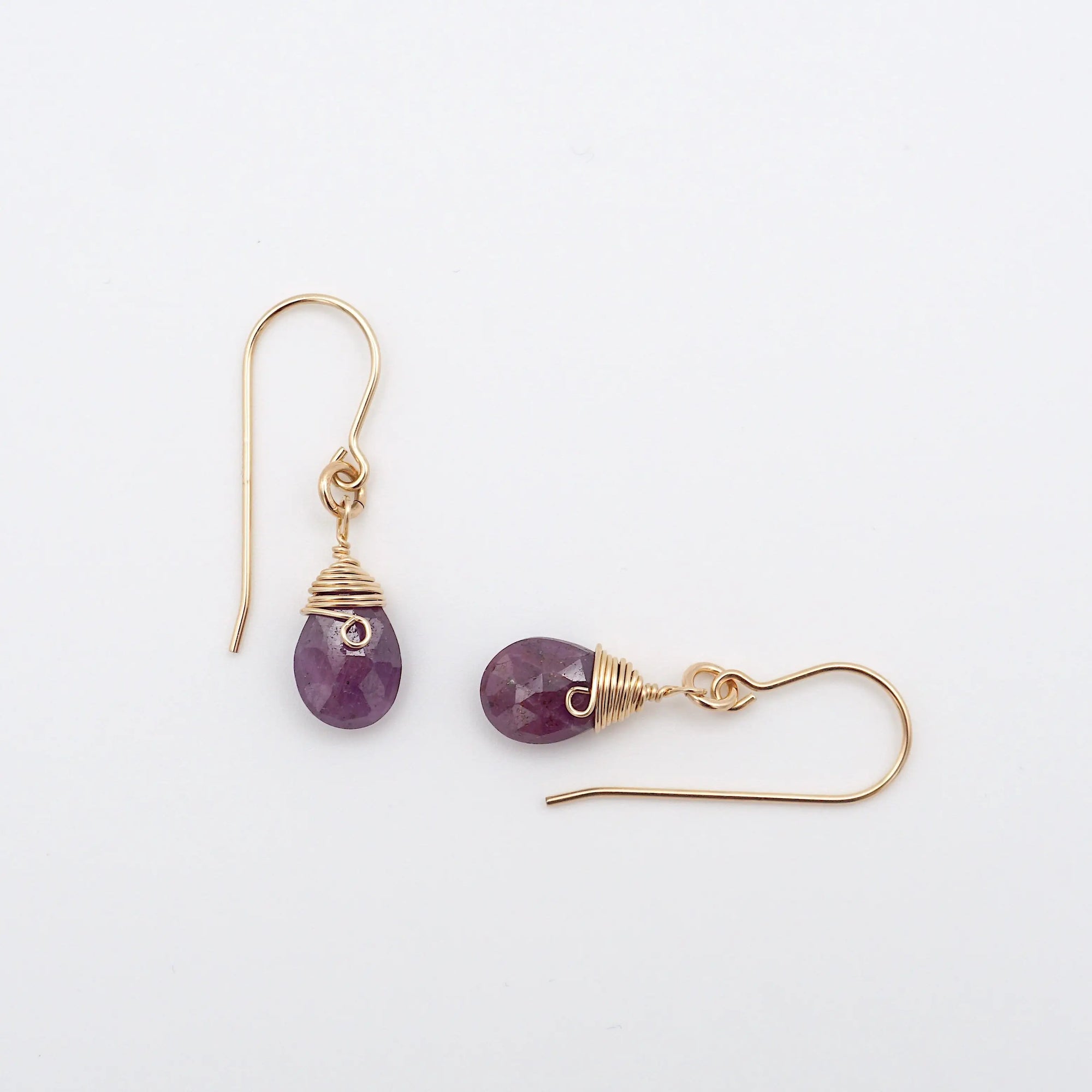 Closeup showing details of ruby drop earrings, faceted ruby stone, 14k gold filled setting