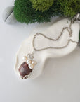 Handmade silver wire wrapped ruby and freshwater pearl necklace laying flat on a silver plated chain, artisan jewelry for women