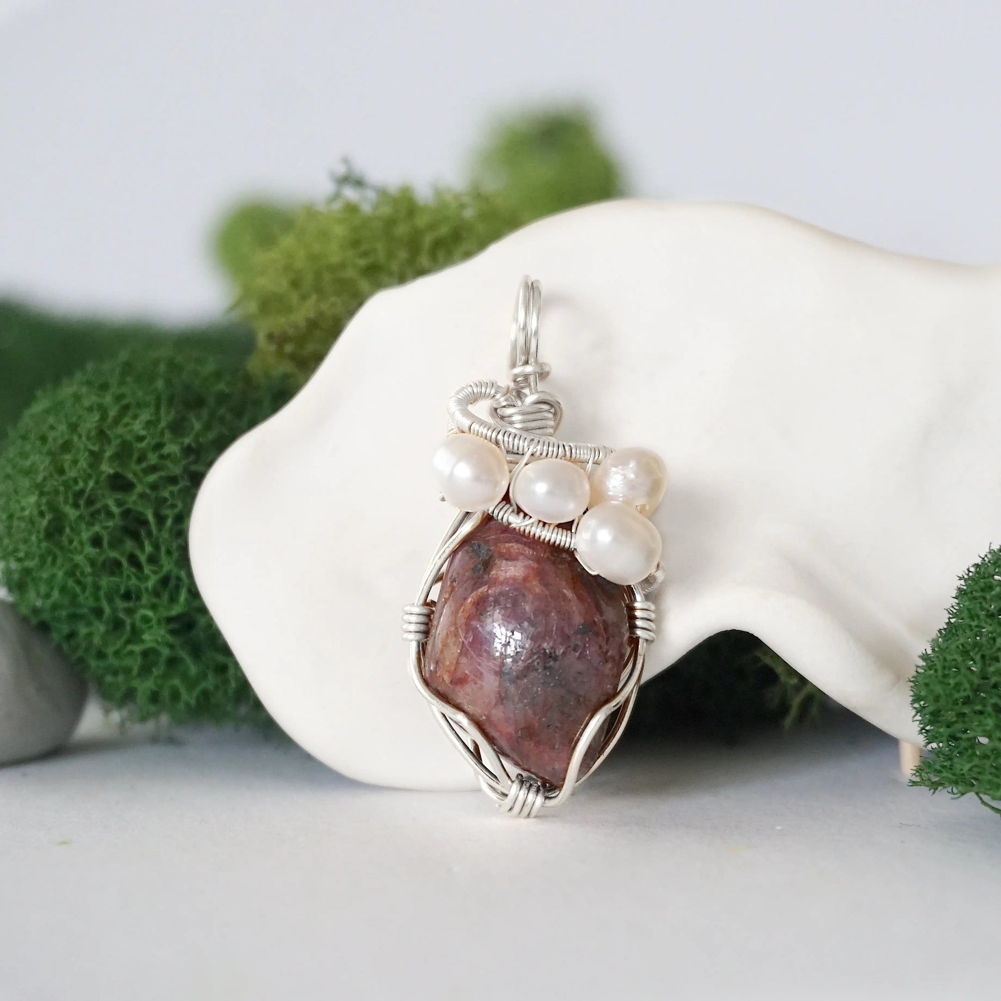 Detailed front view of silver wire wrapped ruby and freshwater pearl pendant, unique artisan necklace
