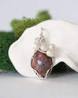 Detailed front view of silver wire wrapped ruby and freshwater pearl pendant, unique artisan necklace
