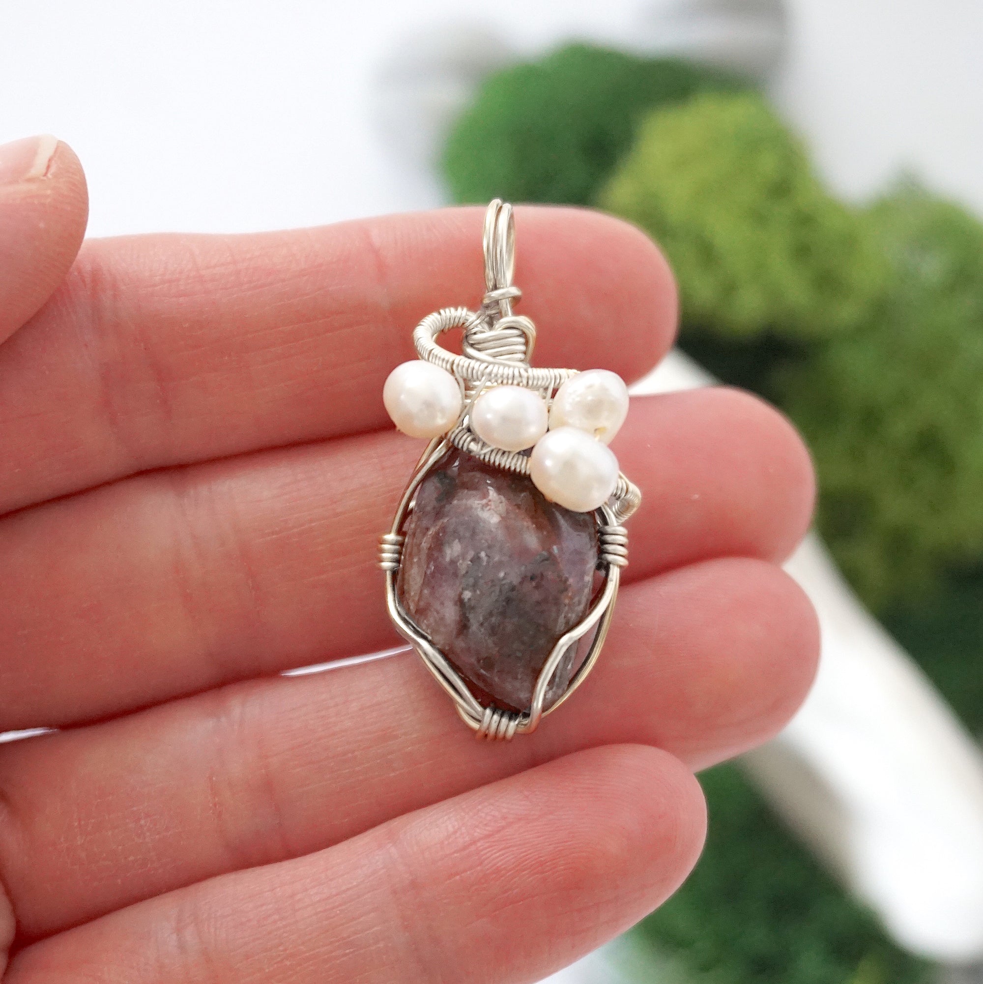 Ruby and freshwater pearl pendant necklace in hand for size reference, silver wire wrapped, handcrafted gemstone jewelry