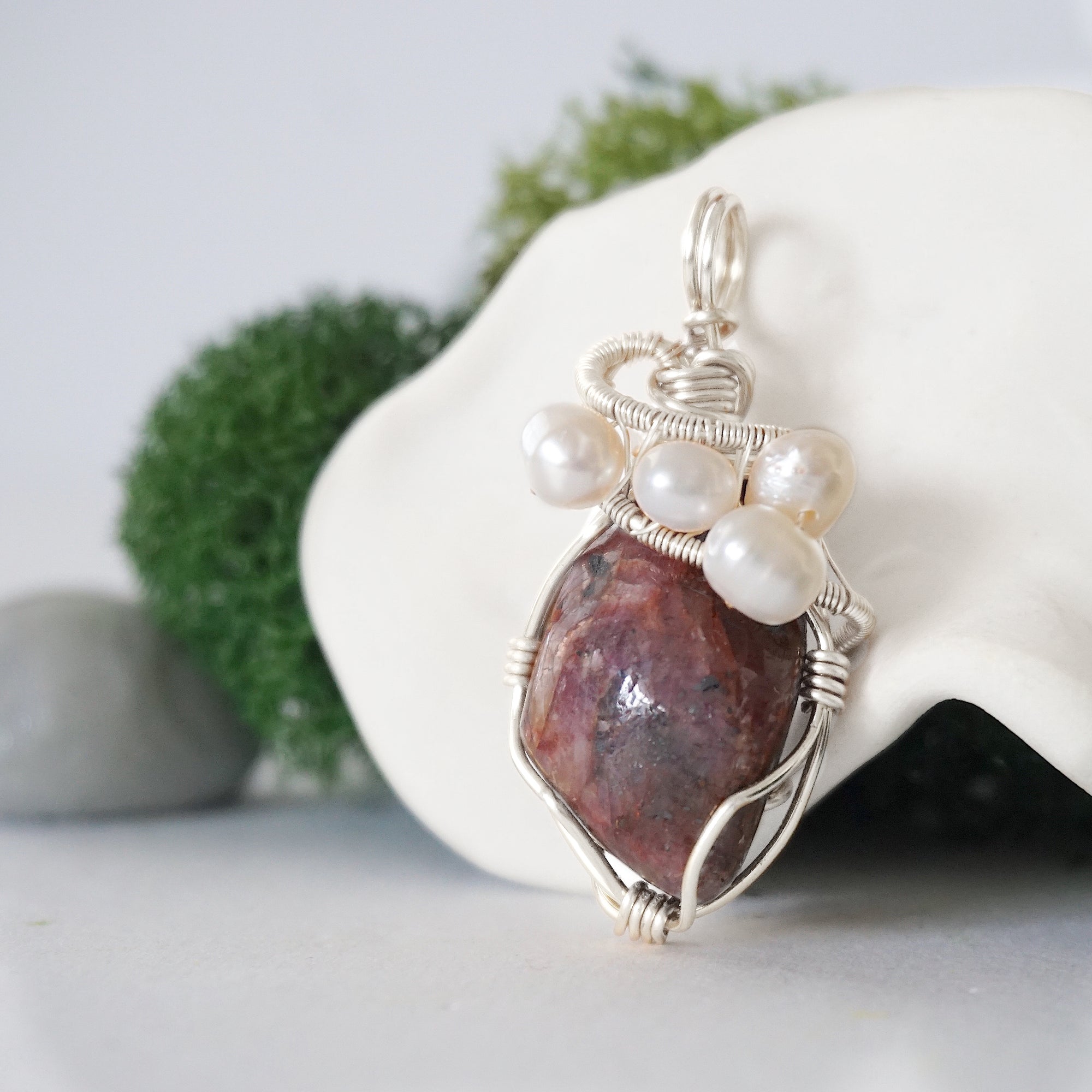 Side angle of handmade ruby and freshwater pearl pendant necklace, silver wire wrapped jewelry