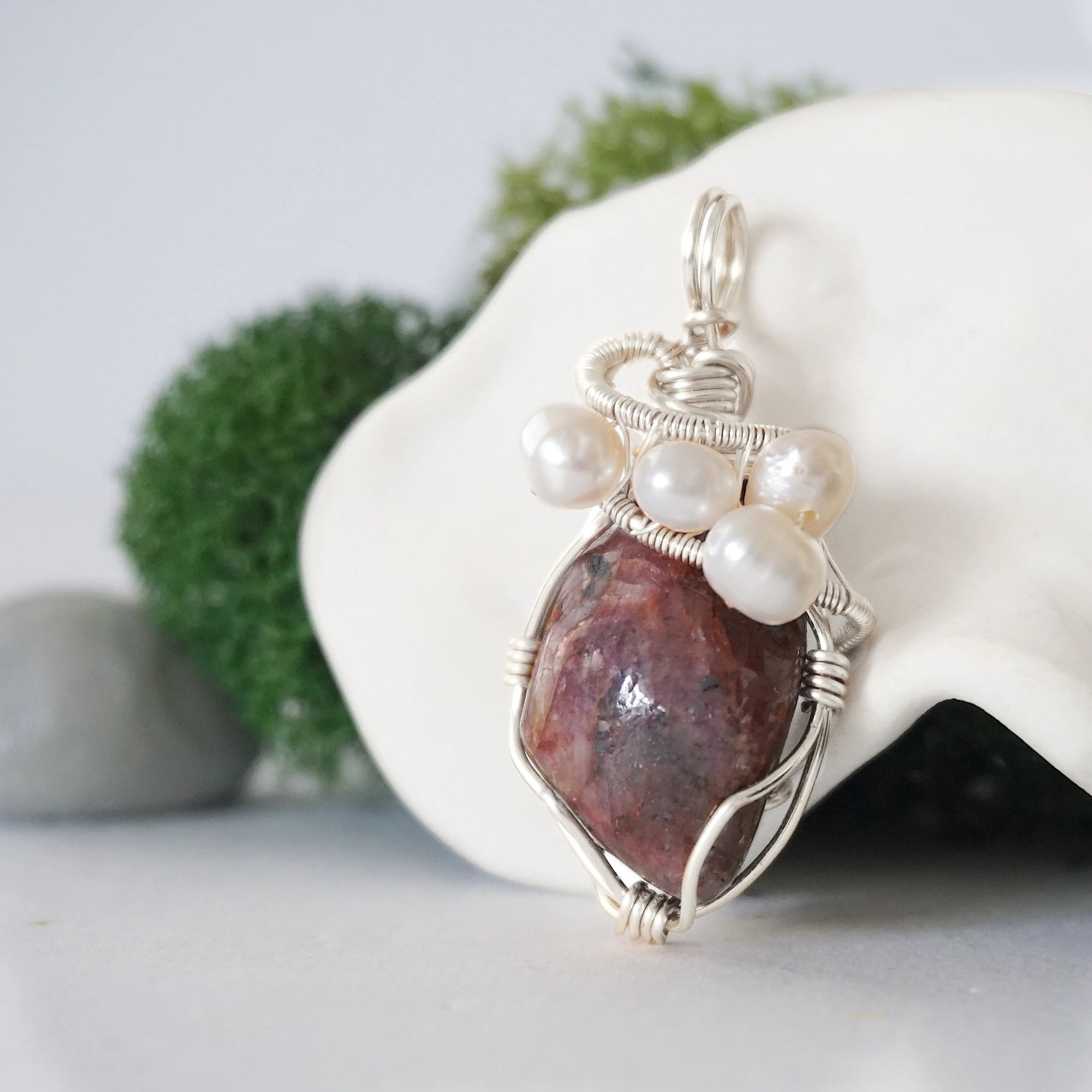Side angle of handmade ruby and freshwater pearl pendant necklace, silver wire wrapped jewelry