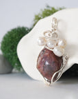 Side angle of handmade ruby and freshwater pearl pendant necklace, silver wire wrapped jewelry
