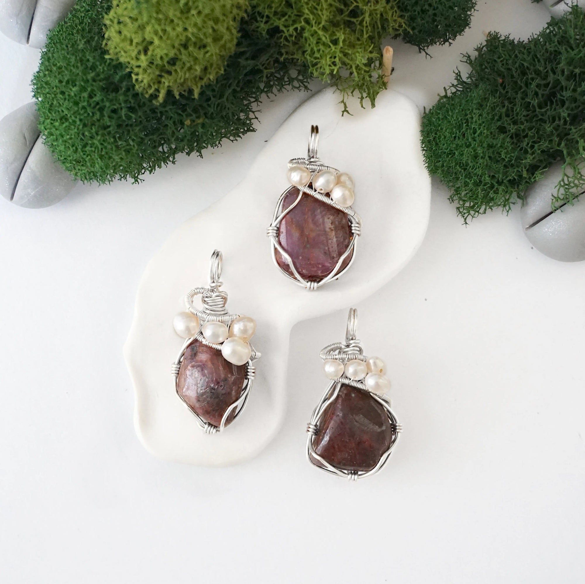 Three silver wire wrapped ruby and freshwater pearl pendants showing natural stone variation, artisan jewelry for women
