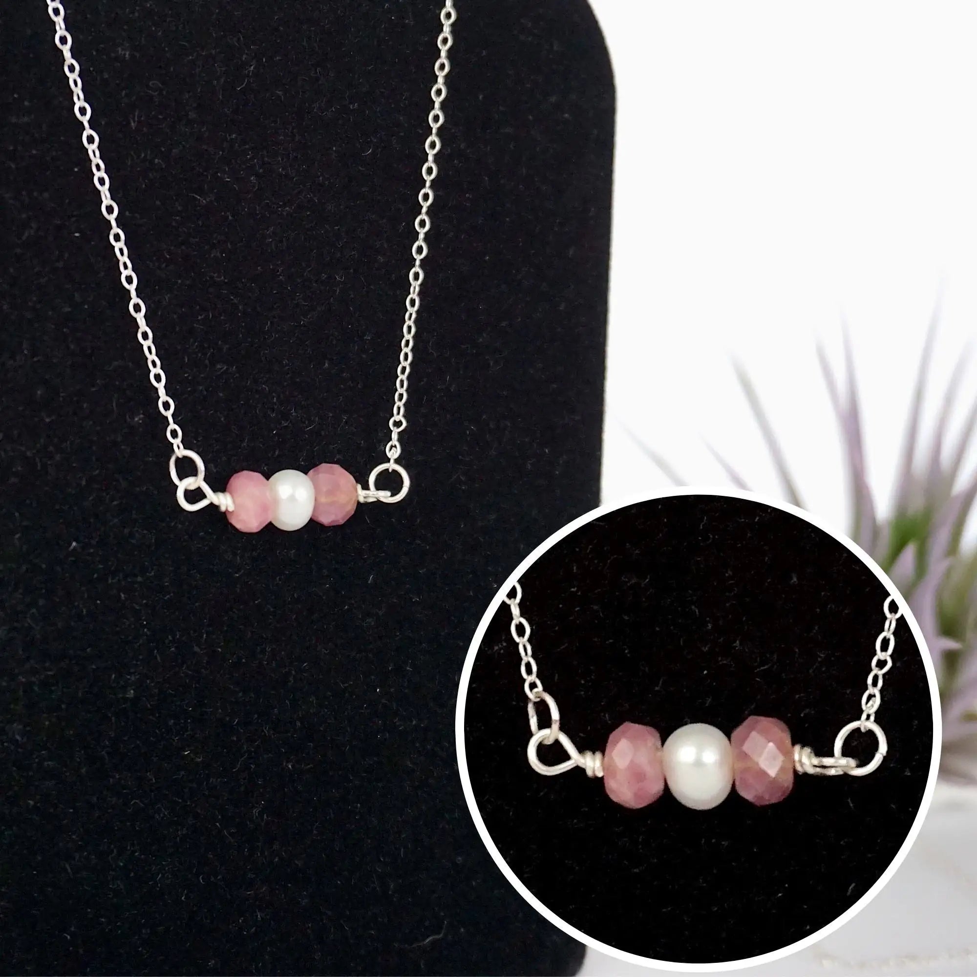 Close-up of raw ruby stones and freshwater pearl bar on 925 sterling silver necklace