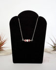 Ruby and freshwater pearl bar necklace in 925 sterling silver on jewelry display, front view