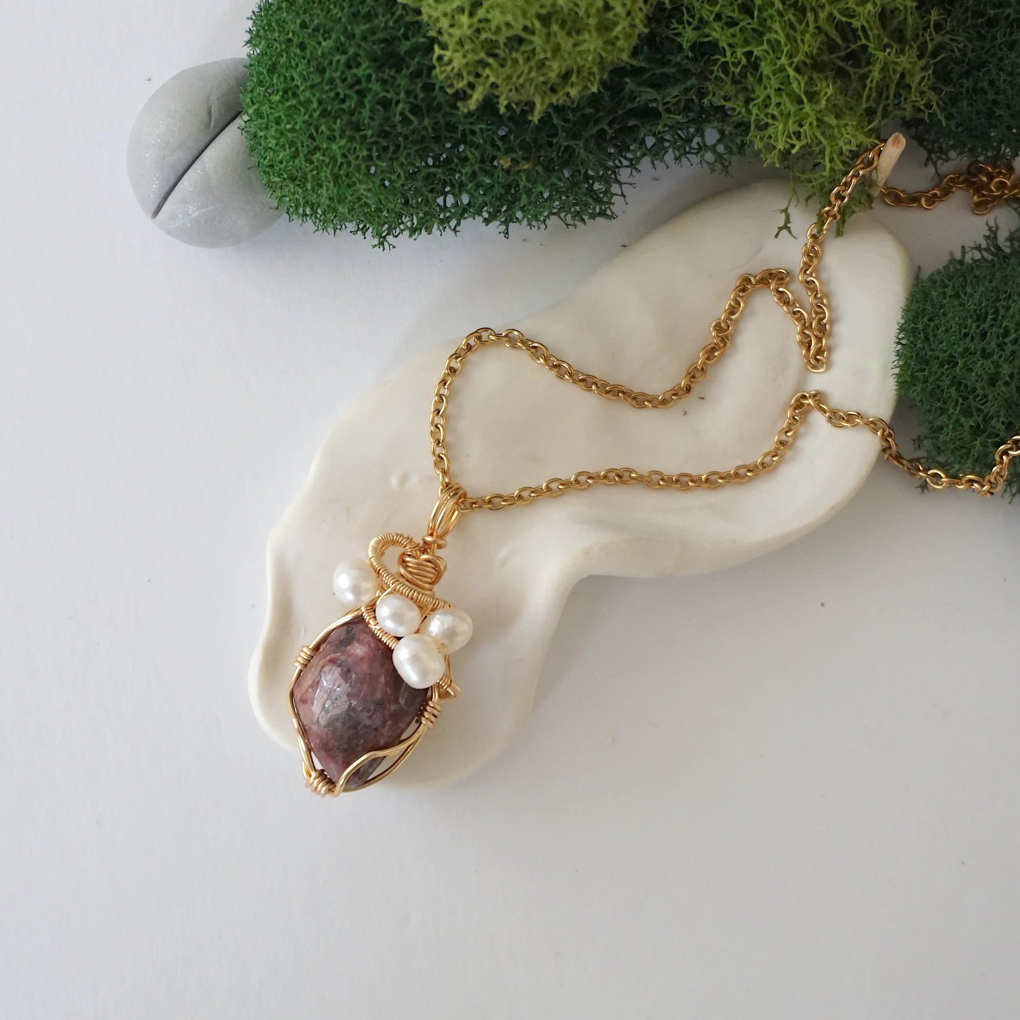 Ruby and freshwater pearl pendant on gold plated brass chain laying flat, handmade wire wrapped jewelry for women