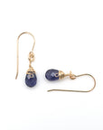 Closeup showing details of sapphire drop earrings, faceted sapphire stone, 14k gold filled setting