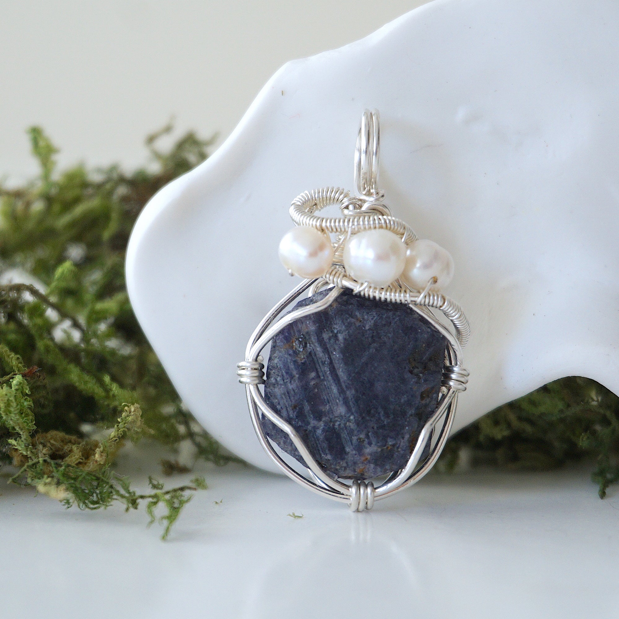 Detailed front view of silver wire wrapped sapphire and freshwater pearl pendant, unique artisan necklace