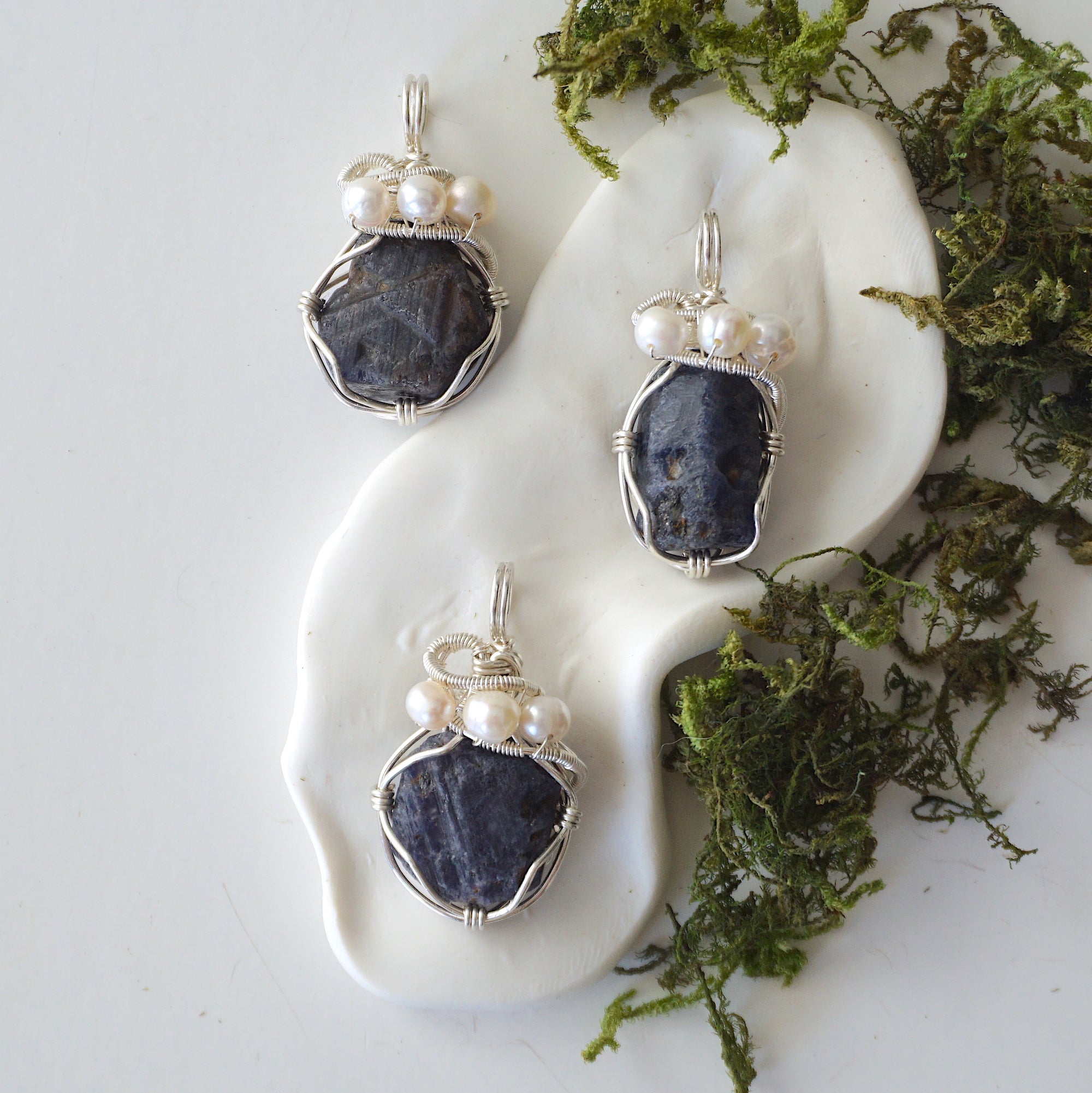 Three silver wire wrapped sapphire and freshwater pearl pendants showing natural stone variation, artisan jewelry for women