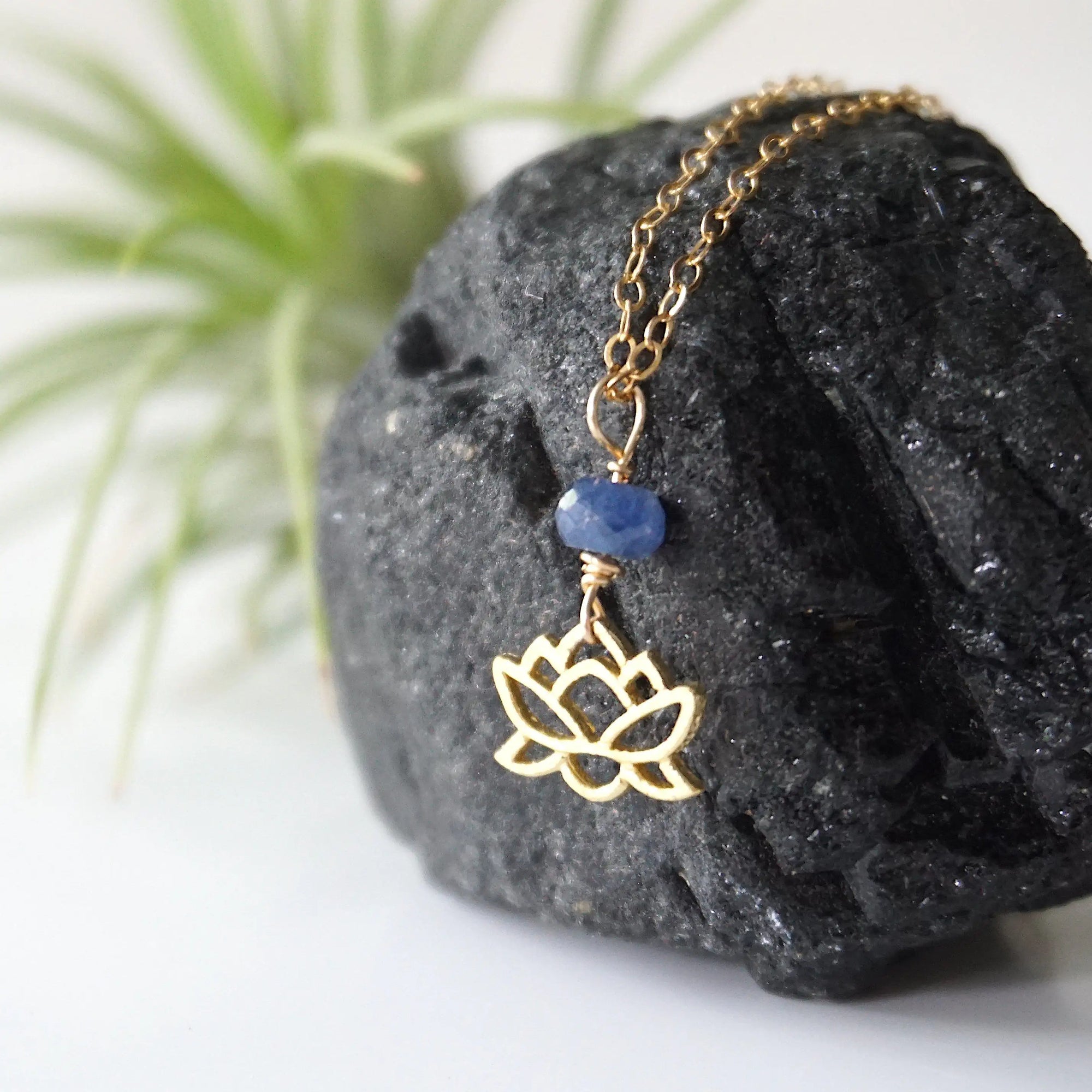 Left-angle detail of faceted sapphire and gold vermeil lotus necklace — handcrafted minimalist birthstone jewelry for women
