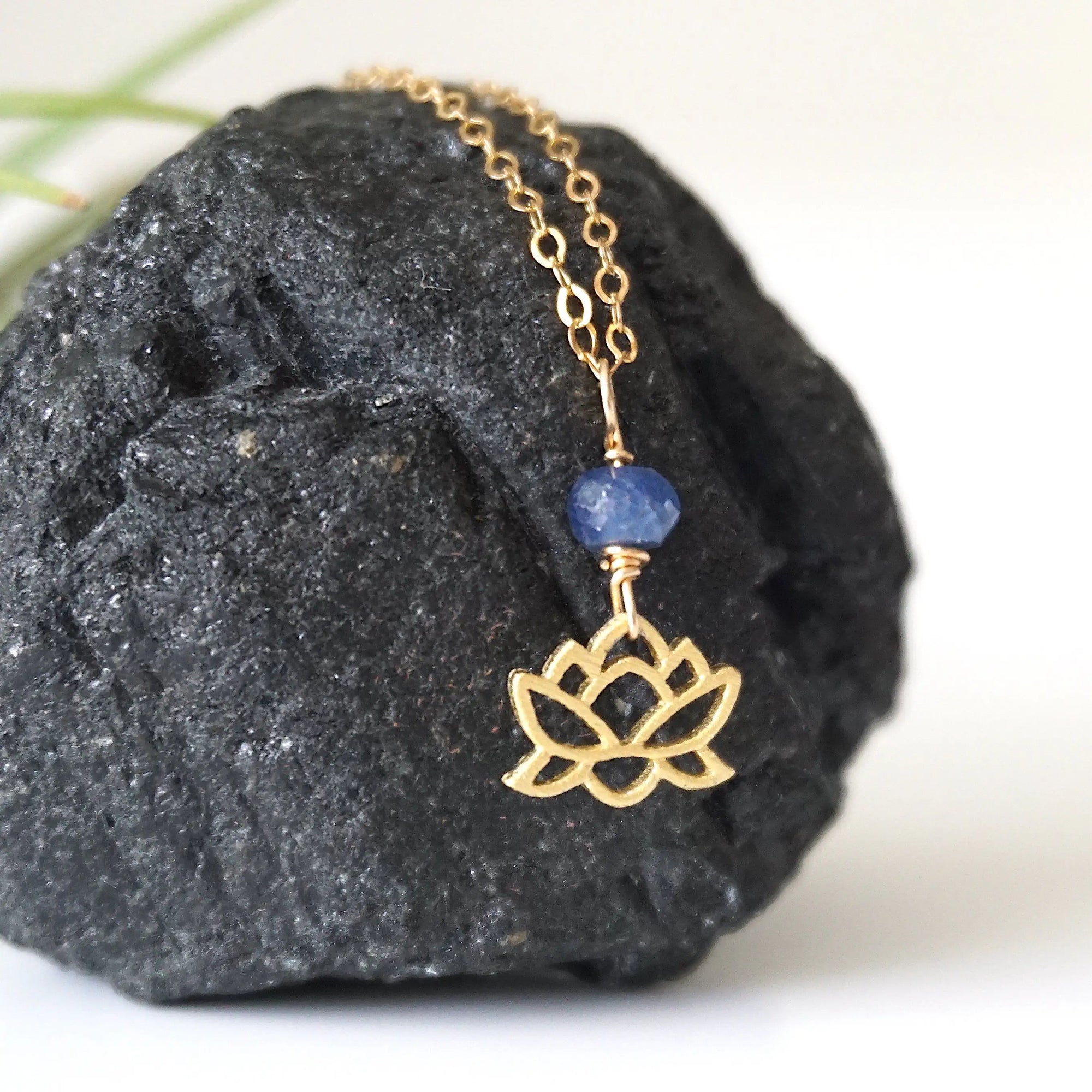 Right-angle detail of natural faceted sapphire and lotus necklace showing the gold vermeil charm and minimalist artisan design