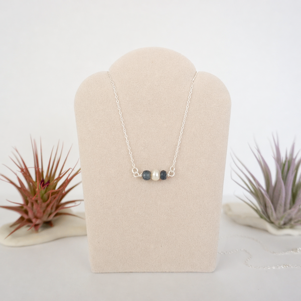 Sapphire and freshwater pearl bar necklace in 925 sterling silver on jewelry display, front view