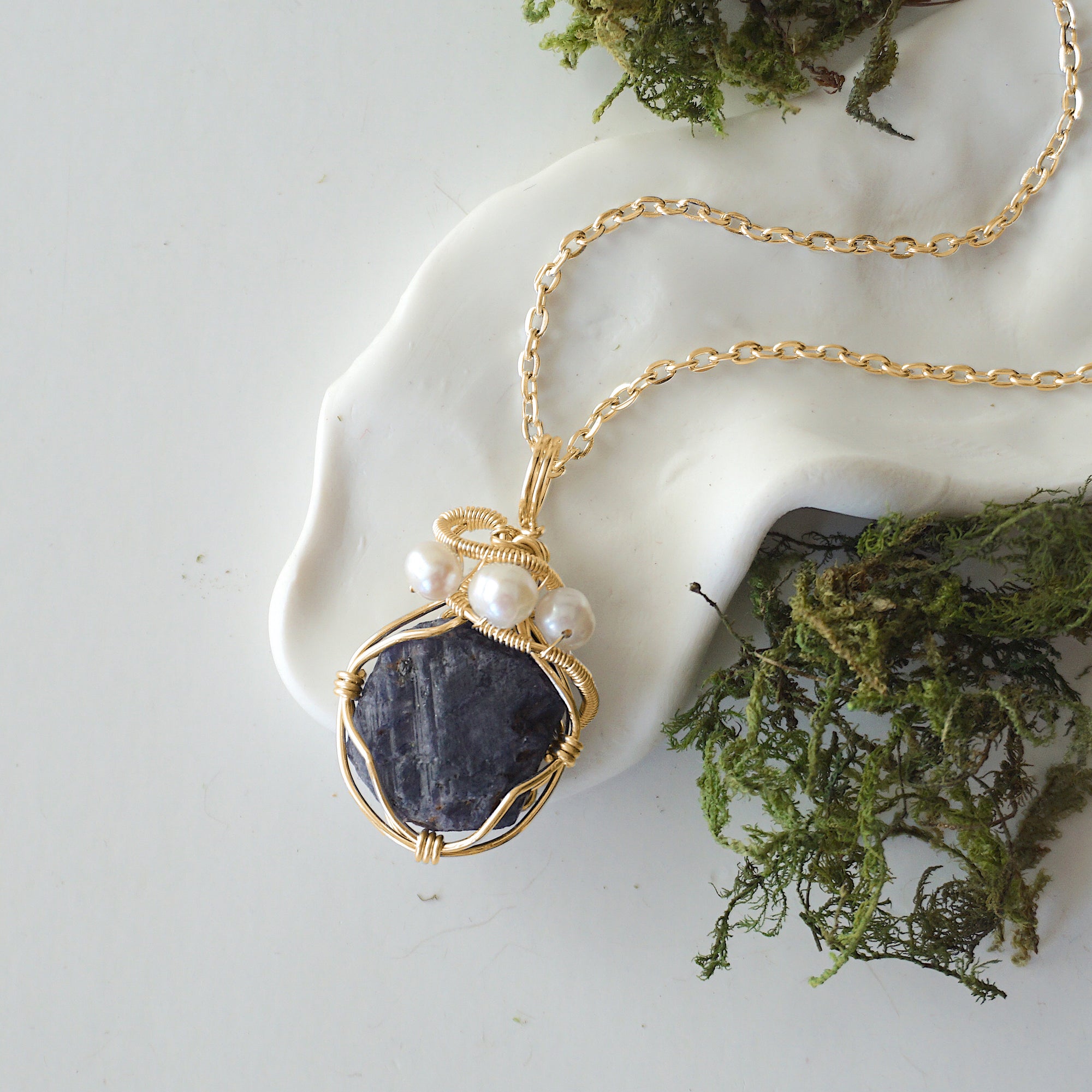 Sapphire and freshwater pearl pendant on gold plated brass chain laying flat, handmade wire wrapped jewelry for women