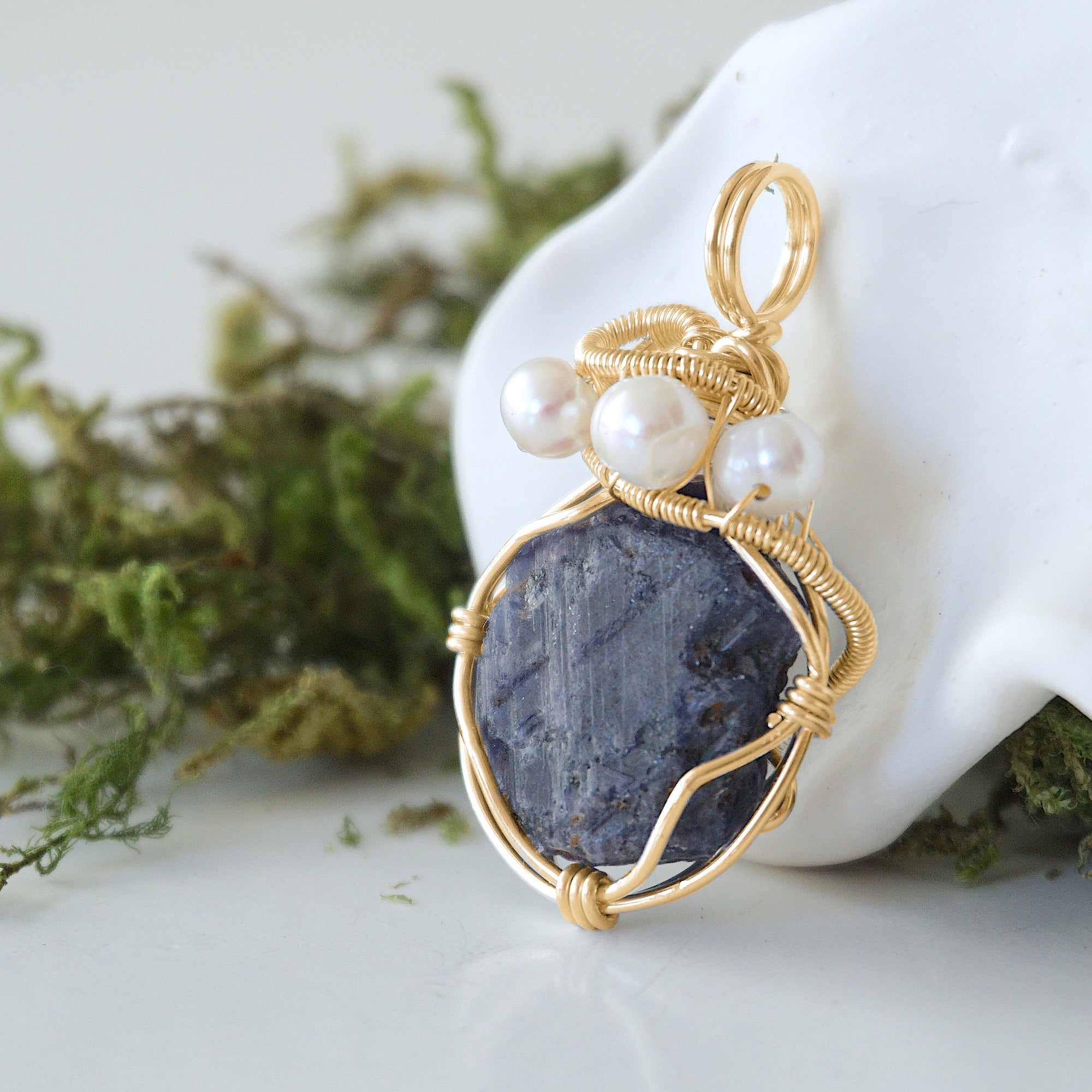 Side angle detail of sapphire and freshwater pearl pendant, gold wire wrapped, ethical artisan necklace