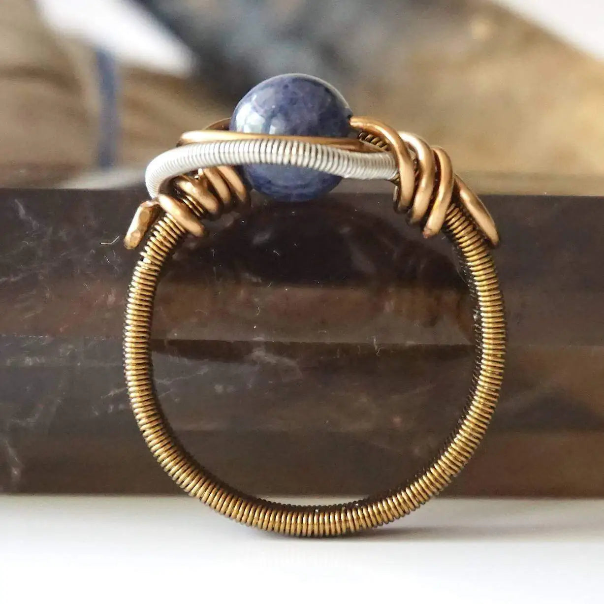 Detail of approximately 4mm sapphire ring band with antique bronze and dark silver wire-wrapped artisan finish