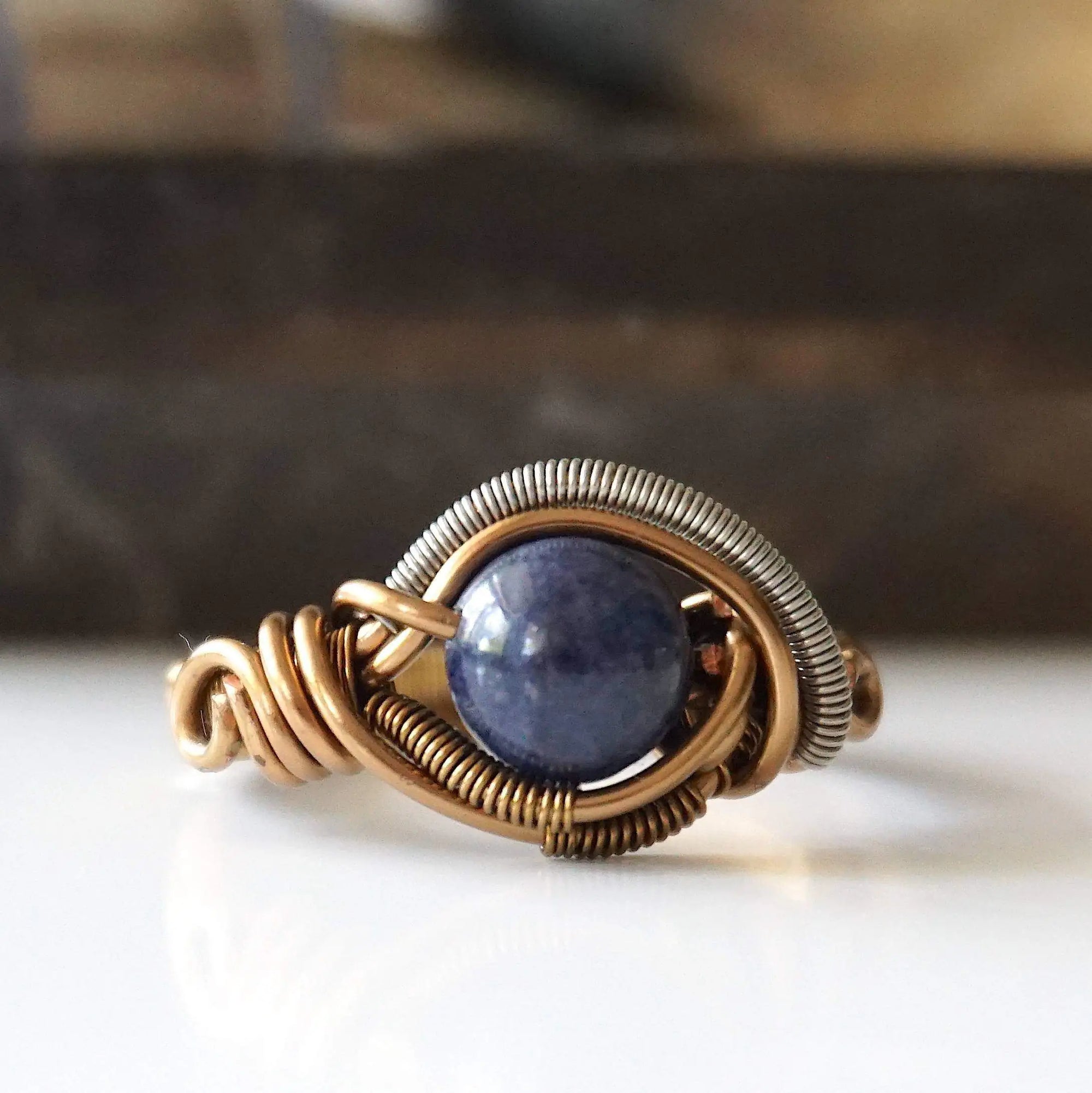 Front view of natural 8mm sapphire ring focused on the stone and mixed antique bronze and dark silver wire wrapping