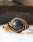 Front view of natural 8mm sapphire ring focused on the stone and mixed antique bronze and dark silver wire wrapping