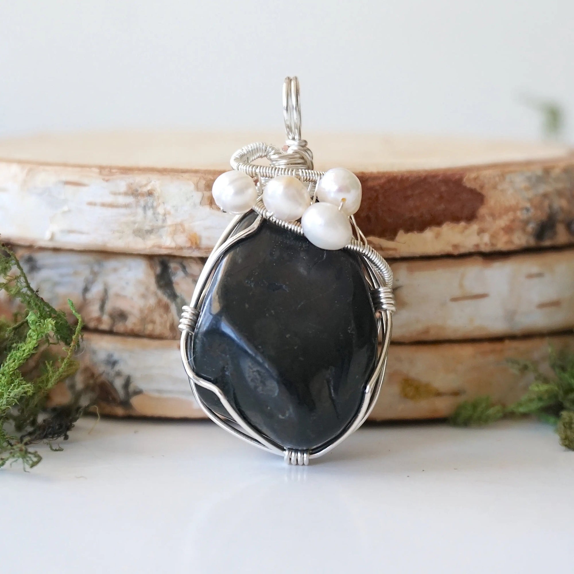 Detailed front view of silver wire wrapped shungite and freshwater pearl pendant, unique artisan necklace