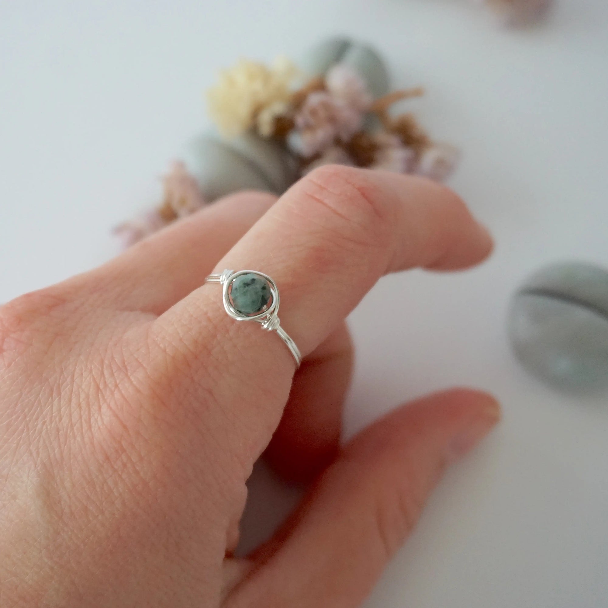 Minimalist silver emerald ring on a model's hand by Designs by Nature Gems, handcrafted May birthstone ring for women.