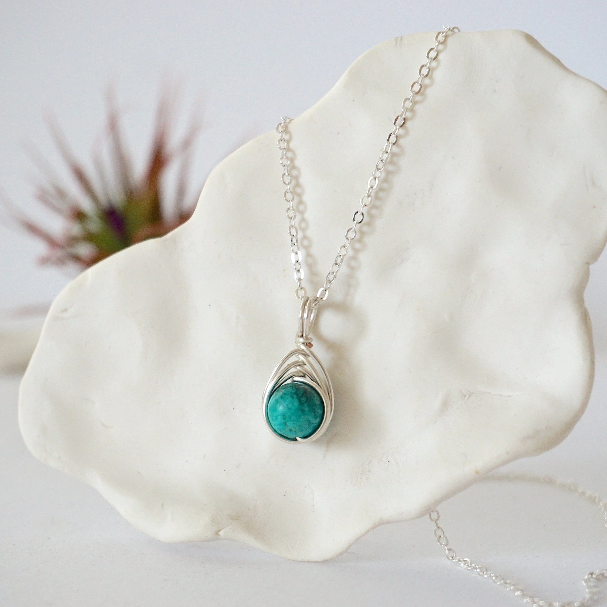 Left side angle of silver plated turquoise necklace showing wire wrap detail