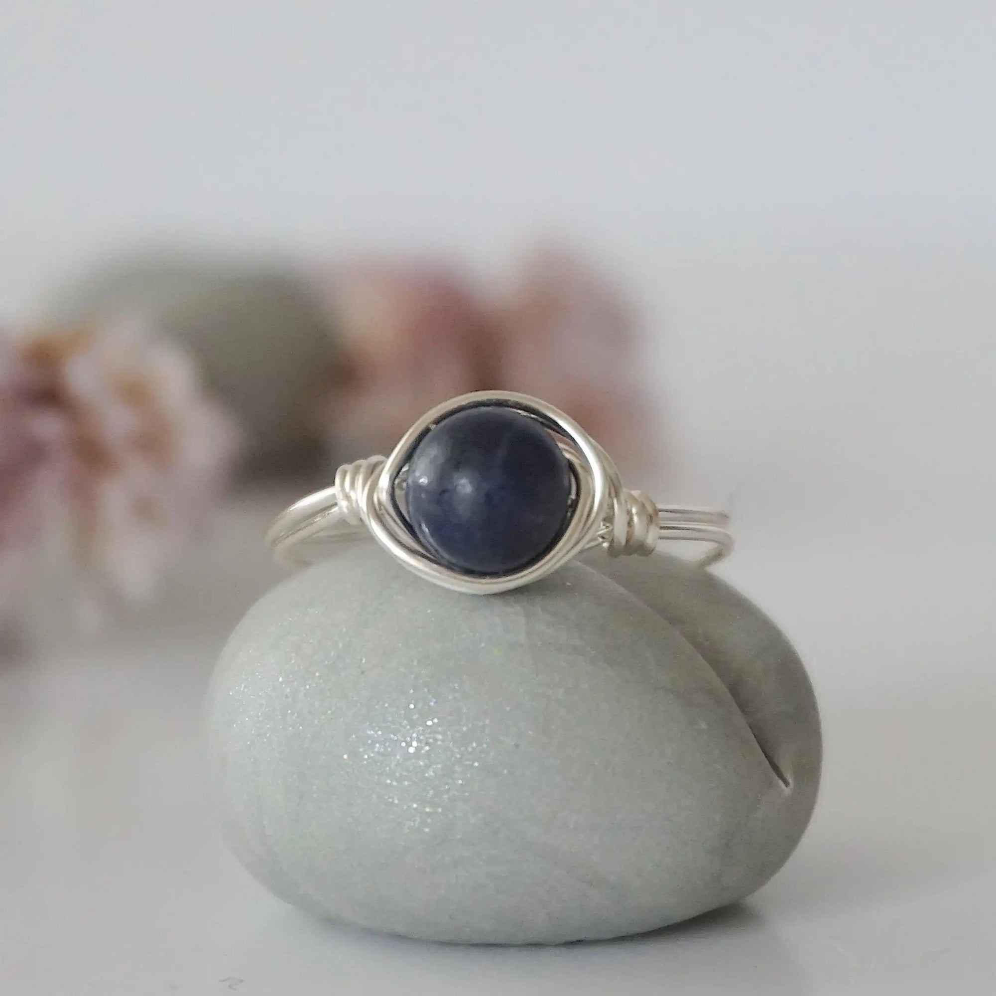 Front-angle detail of silver wire-wrapped sapphire ring showing the classic minimalist artisan setting for women