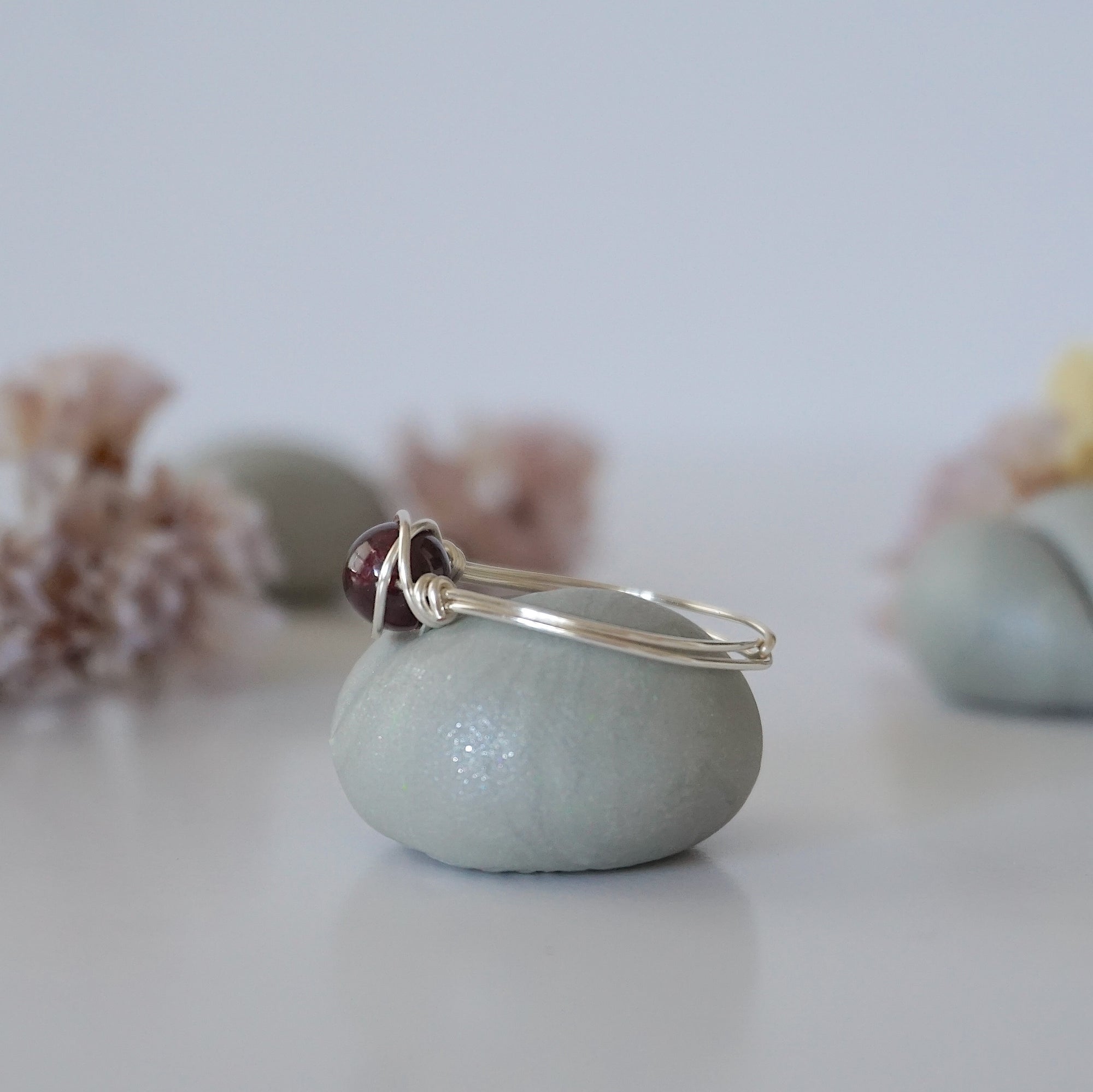 Side angle of simple garnet bead ring with minimalist silver wire wrap, delicate everyday ring