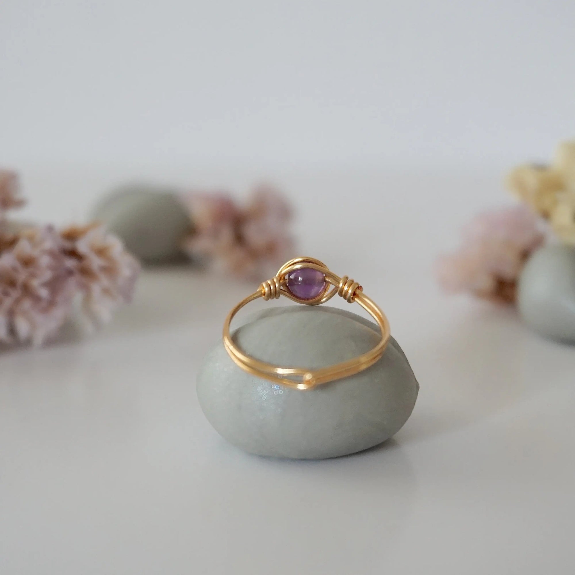 Back view of gold amethyst ring showing minimalist wire wrapped band and polished 6mm amethyst bead setting