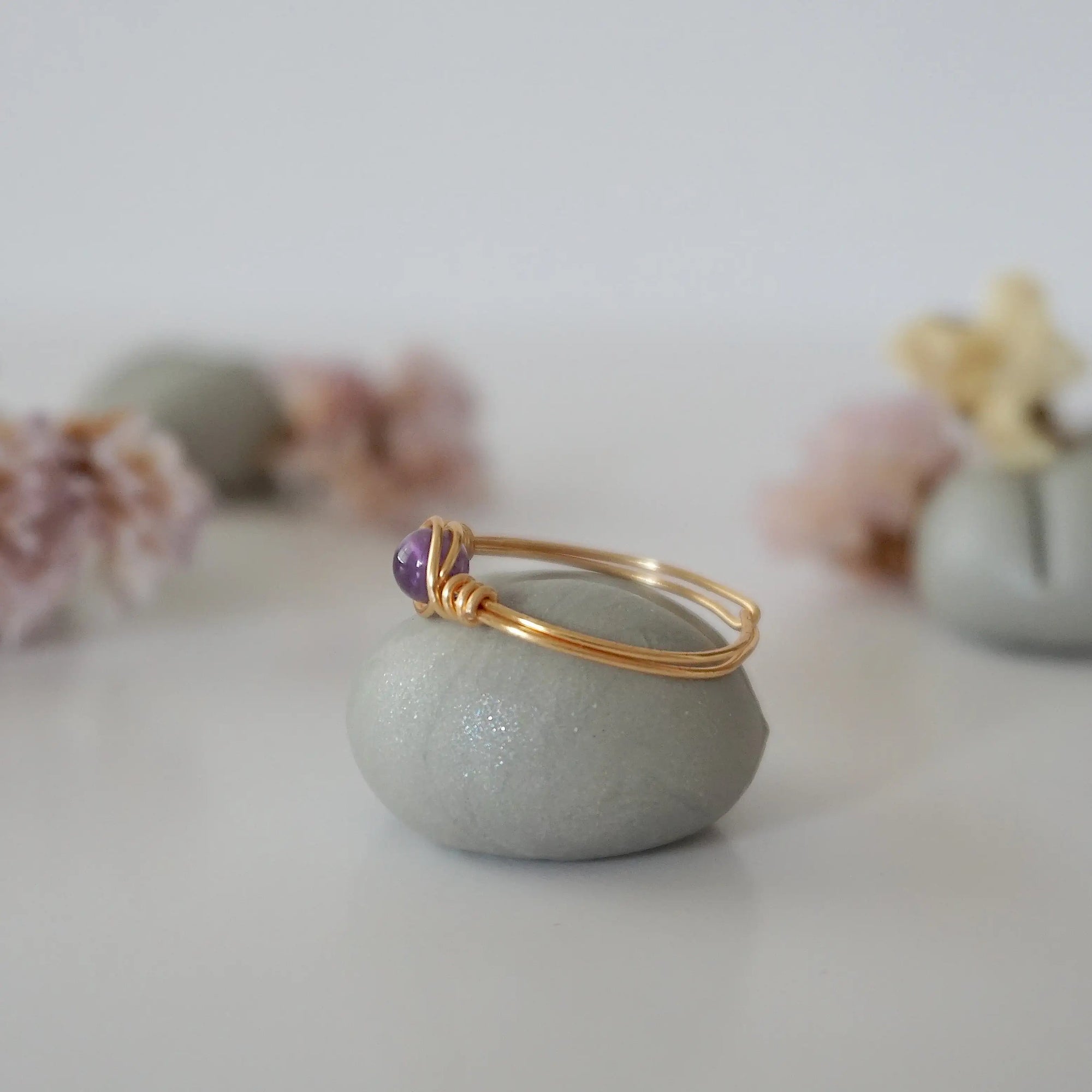Side view detail of gold amethyst ring, minimalist wire wrap holding polished 6mm natural amethyst bead