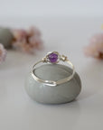 Back view of silver amethyst ring showing minimalist wire wrapped band and polished 6mm amethyst bead setting