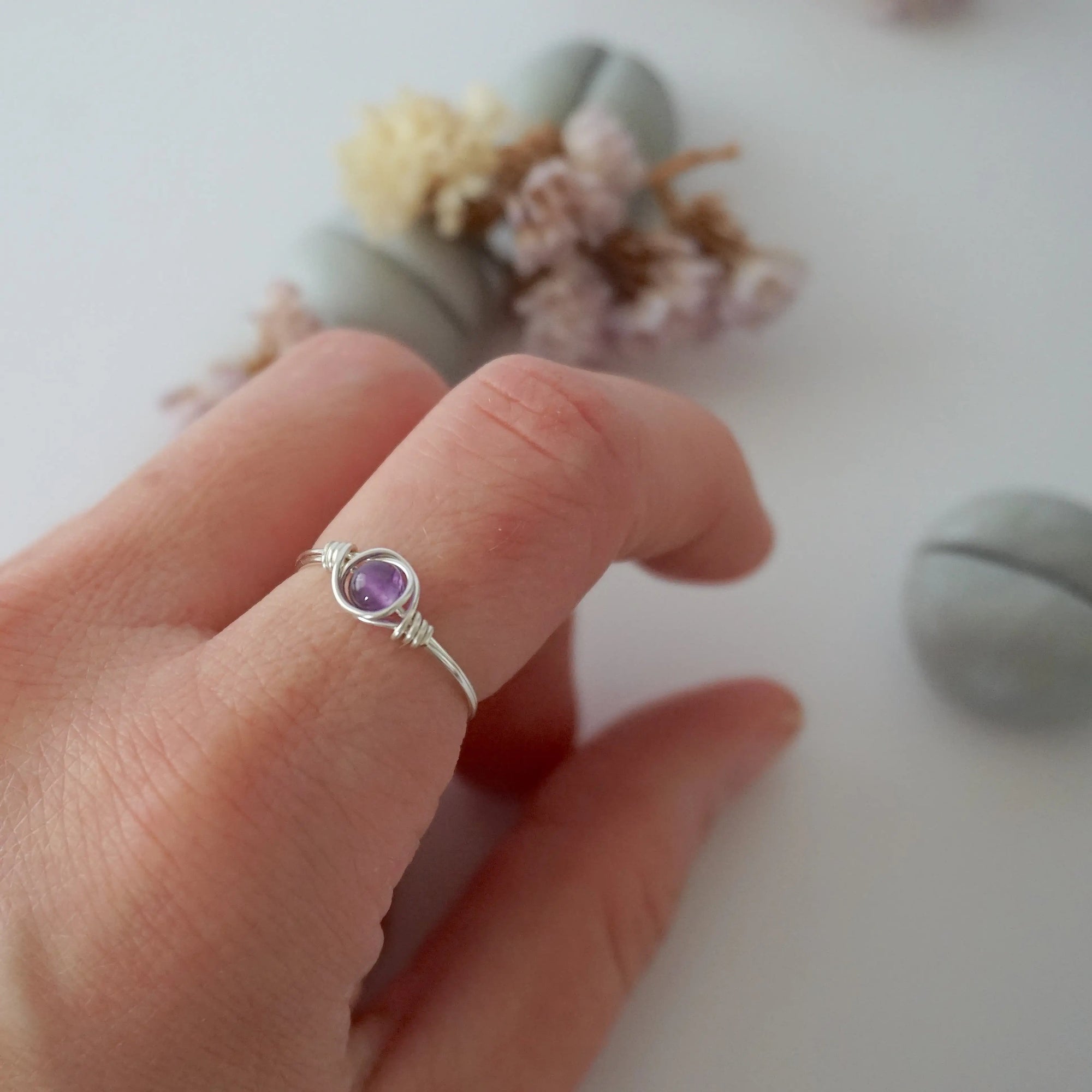 Simple amethyst birthstone ring in silver finish on model hand, minimalist 6mm amethyst bead wire wrap