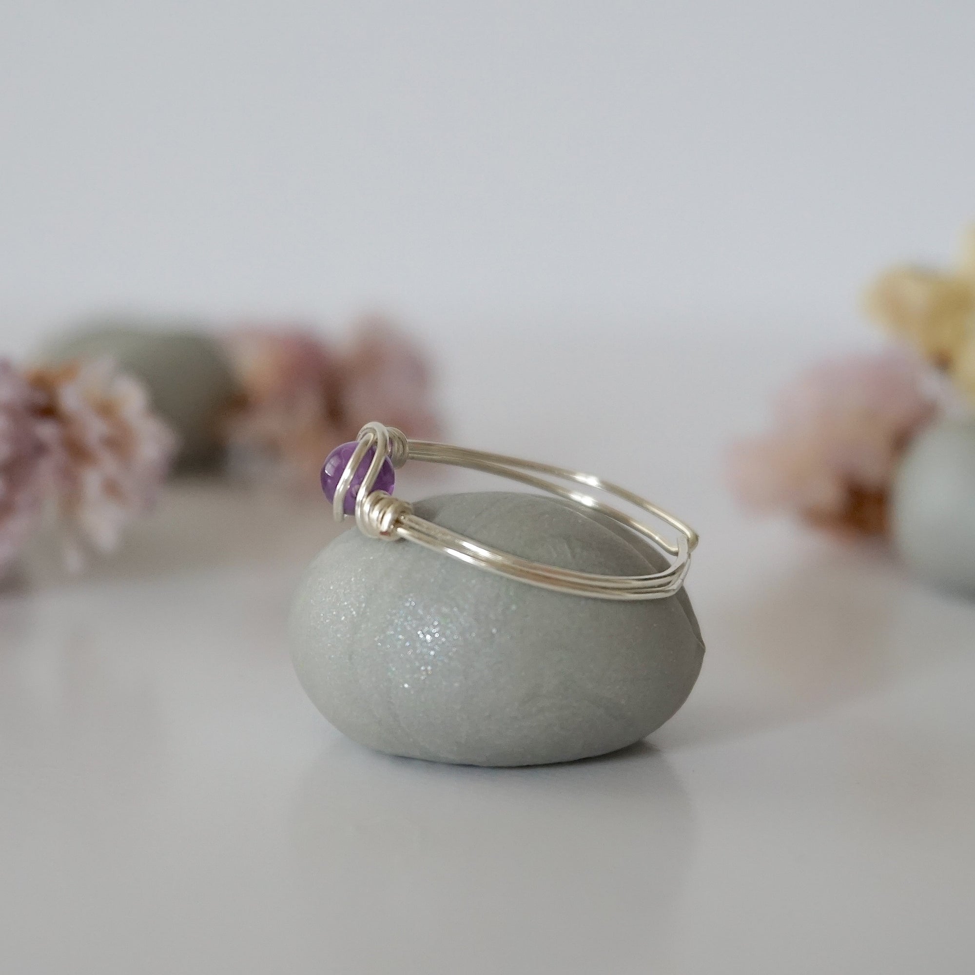 Side view detail of silver amethyst ring, minimalist wire wrap holding polished 6mm natural amethyst bead