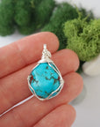 Simple raw turquoise pendant in hand showing size, minimalist wire wrapped crystal necklace scale reference