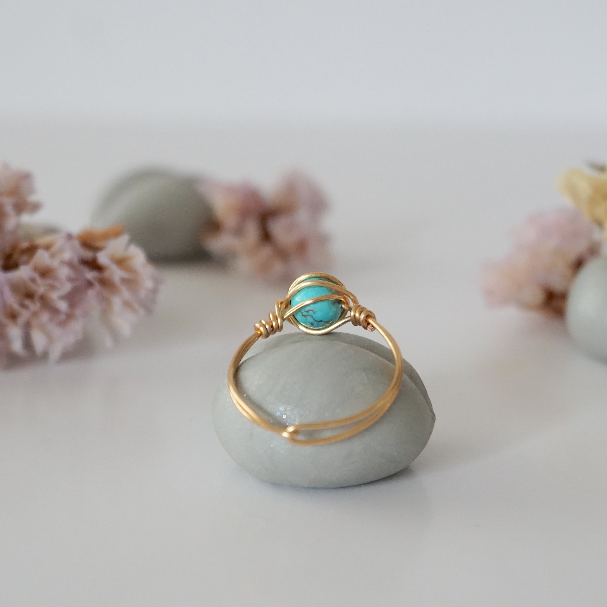 Back view of simple turquoise ring in gold plated copper showing handmade wire wrapping detail and craftsmanship quality