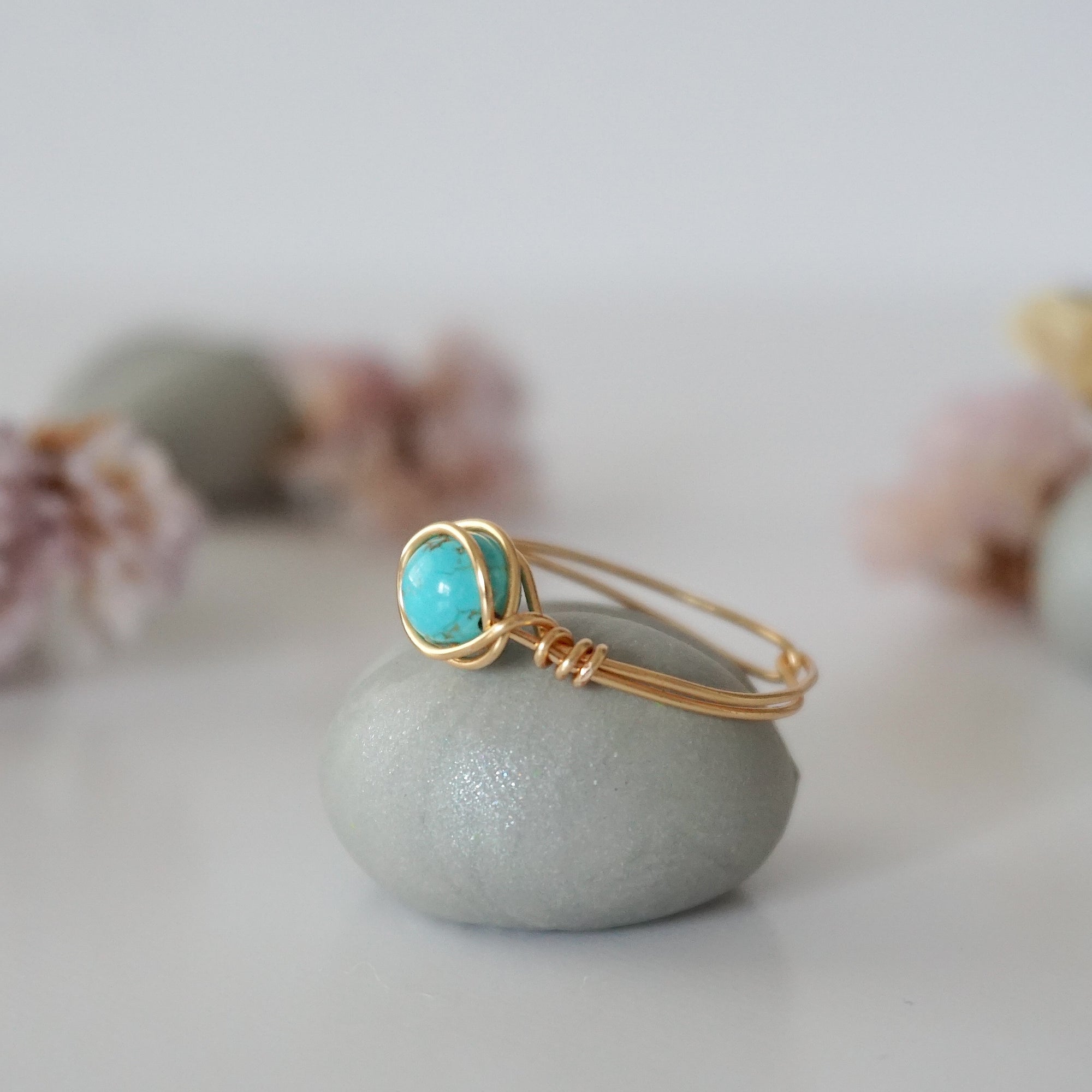Side profile of simple turquoise ring in gold plated copper showing wire wrap technique and 6mm stone setting detail