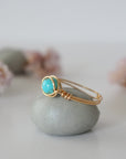 Side profile of simple turquoise ring in gold plated copper showing wire wrap technique and 6mm stone setting detail