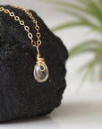Side view of small citrine pendant 14k gold filled showing delicate wire wrapping and natural raw crystal

